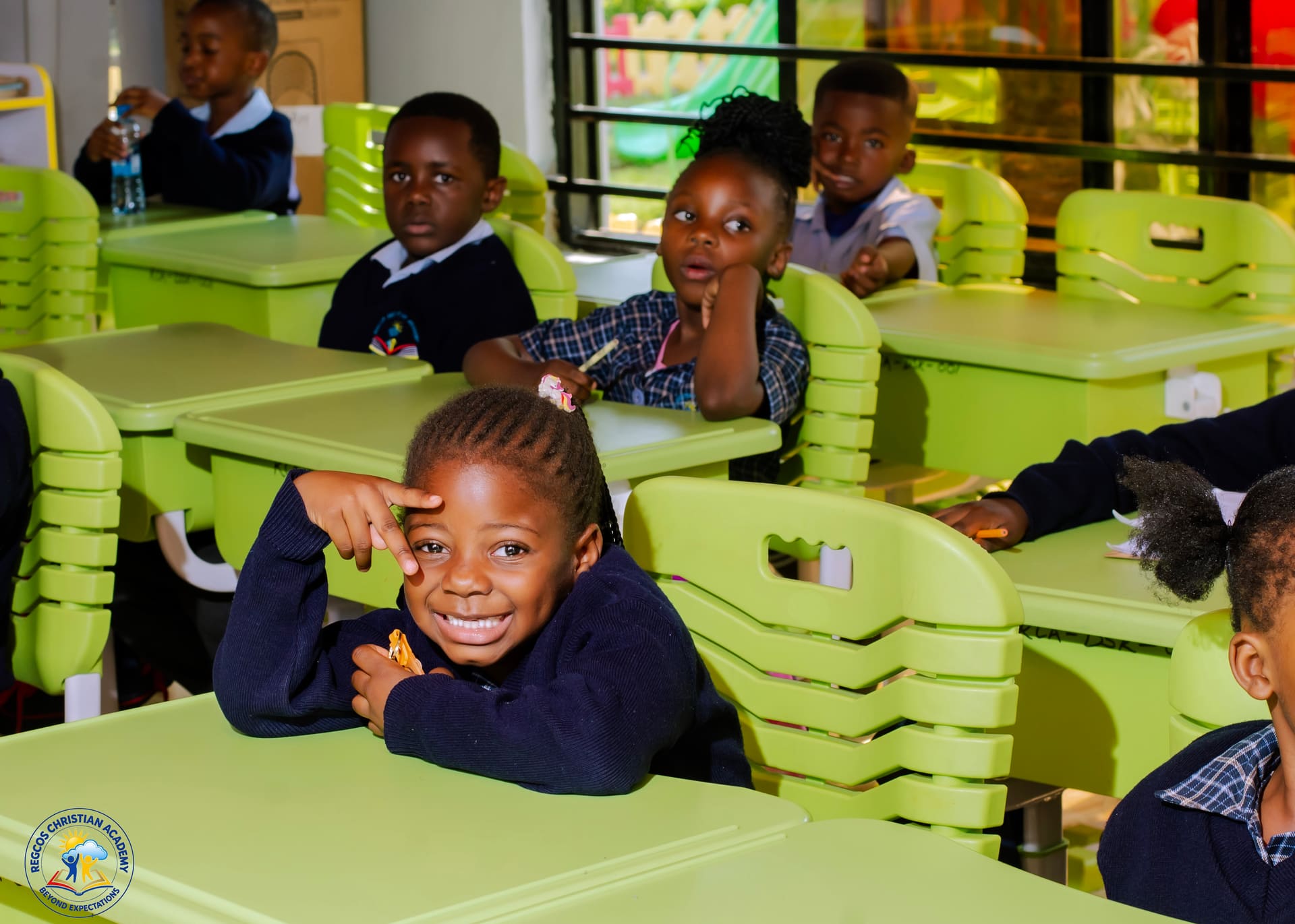 A smiling pupil looking up from her desk during class