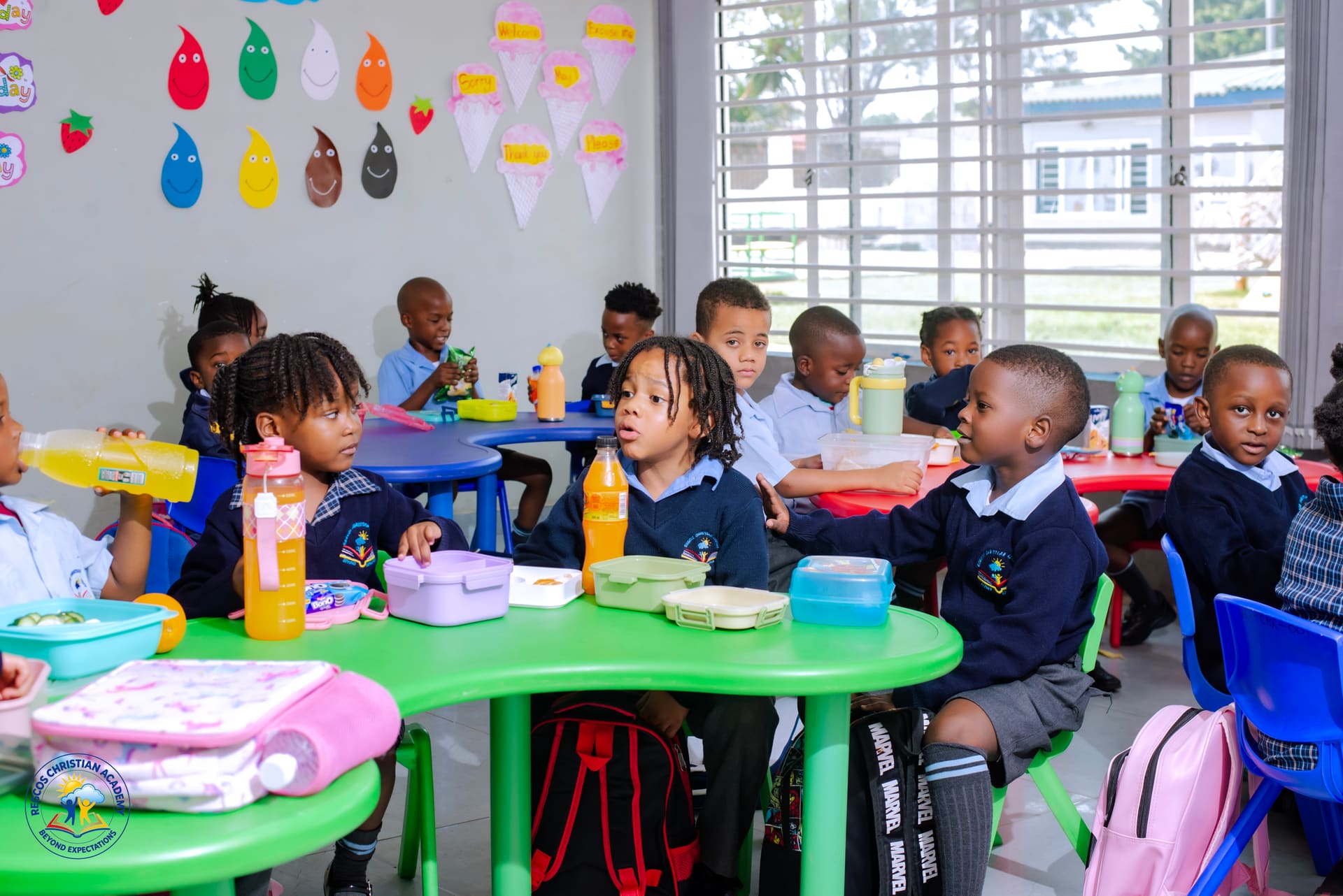 Pupils eating their packed lunches at colourful tables