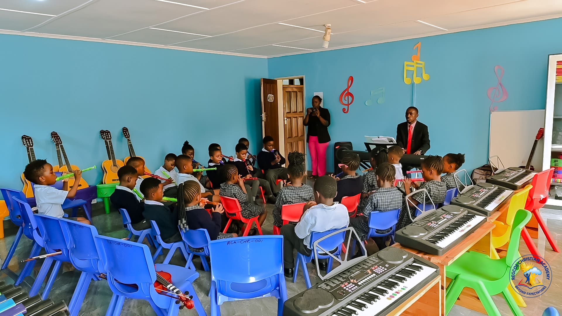 Children playing recorders together in the school music room