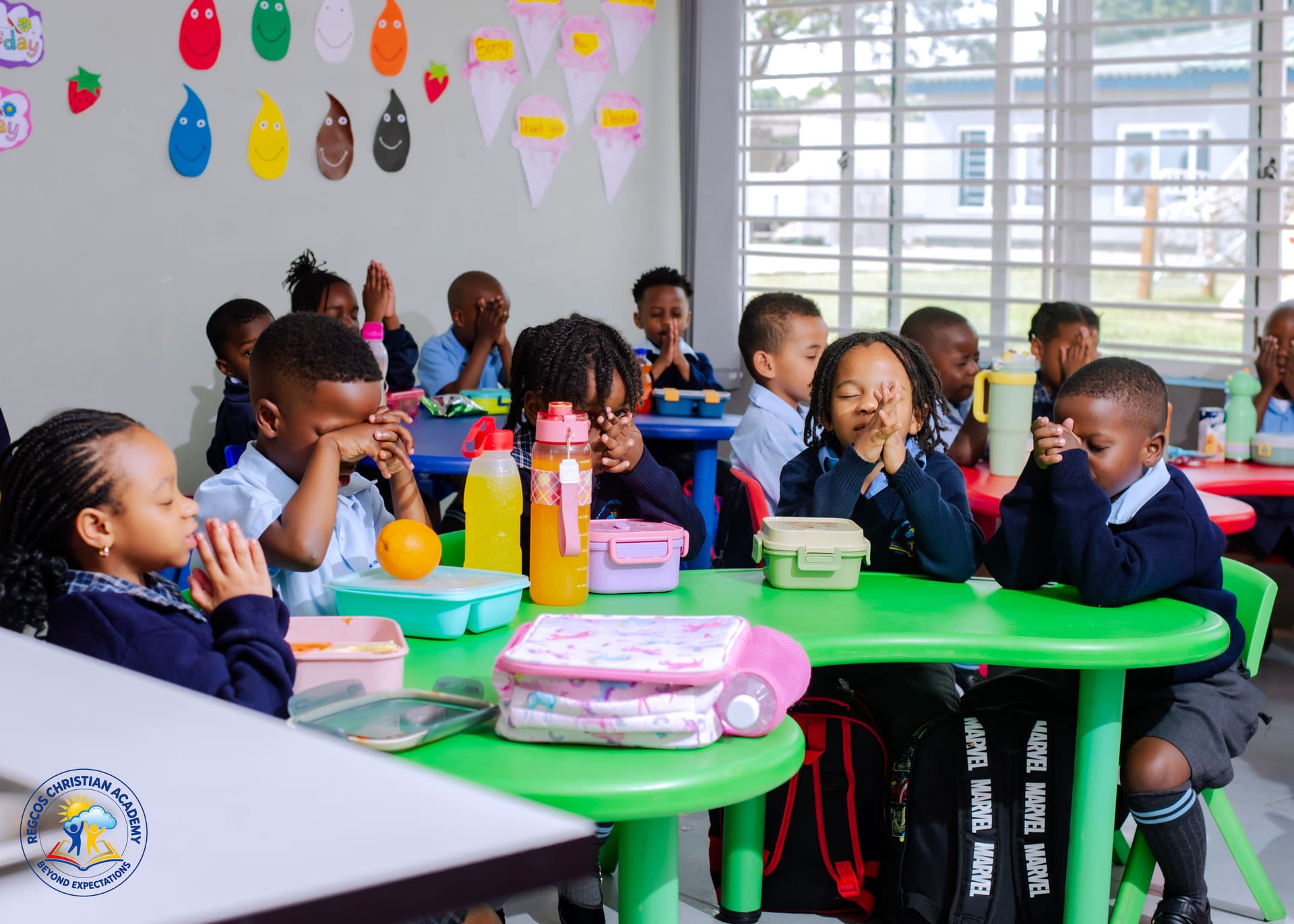 Pupils praying quietly at their classroom tables